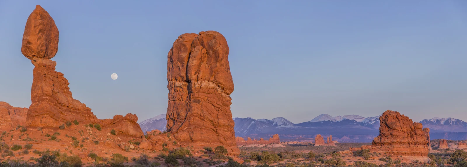 Balanced Rock’s large sandstone block remains attached to a narrowing pedestal above the Arches landscape.