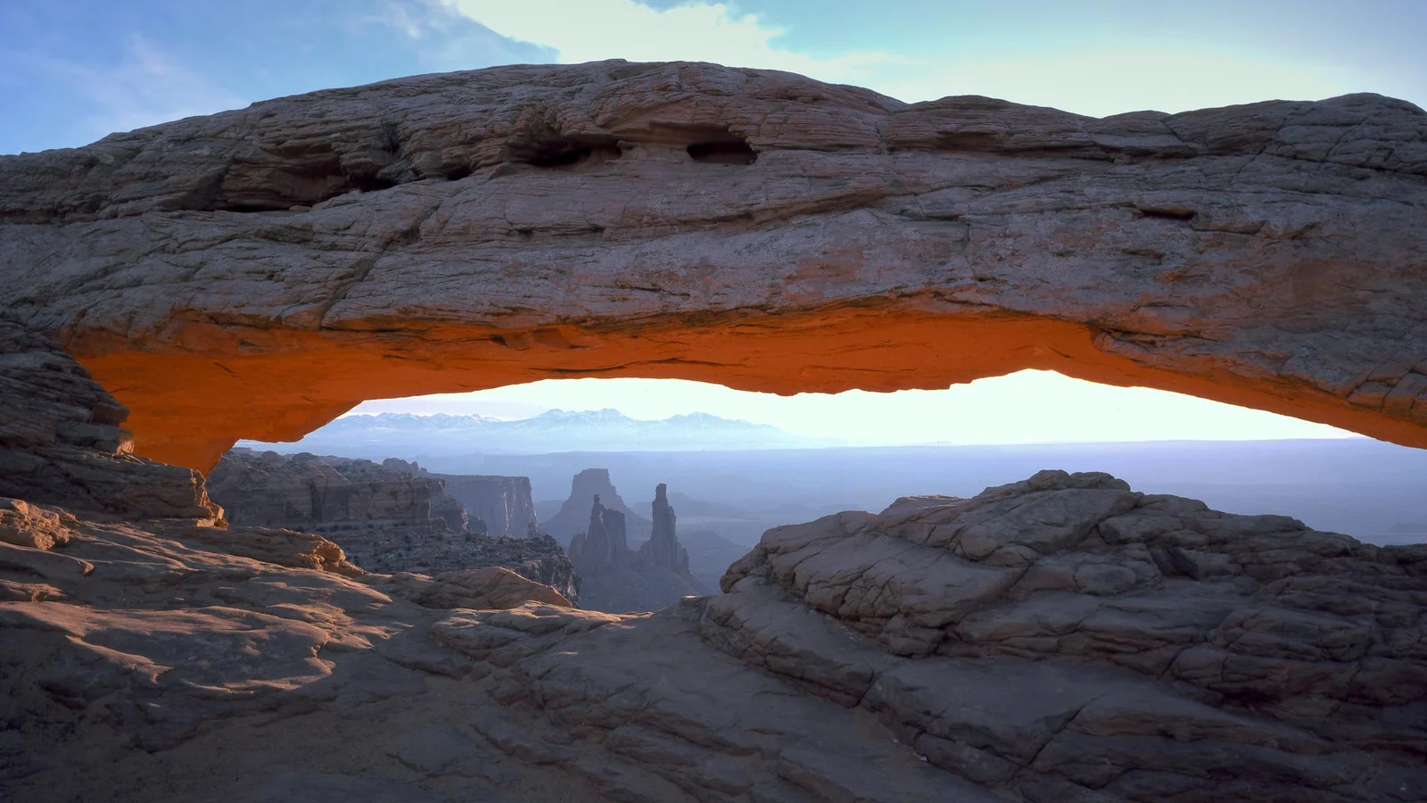 Mesa Arch frames cliffs and the canyon floor from the Island in the Sky mesa.