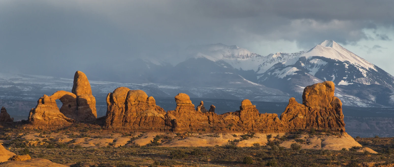 Turret Arch and the Windows area stand against the distant snow-covered La Sal Mountains.