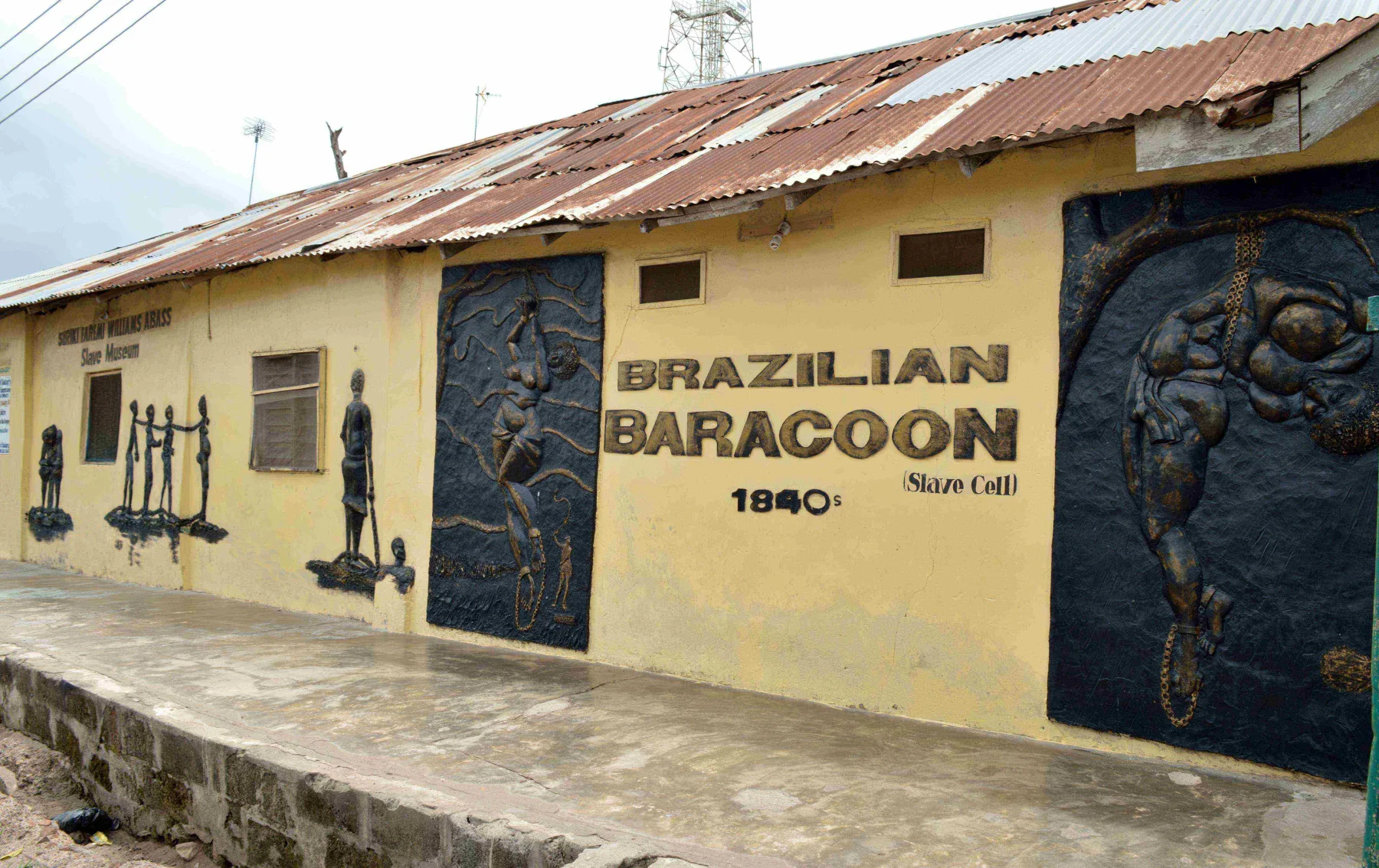 The Brazilian Barracoon museum presents surviving buildings and modern reliefs within the Seriki Abass compound.