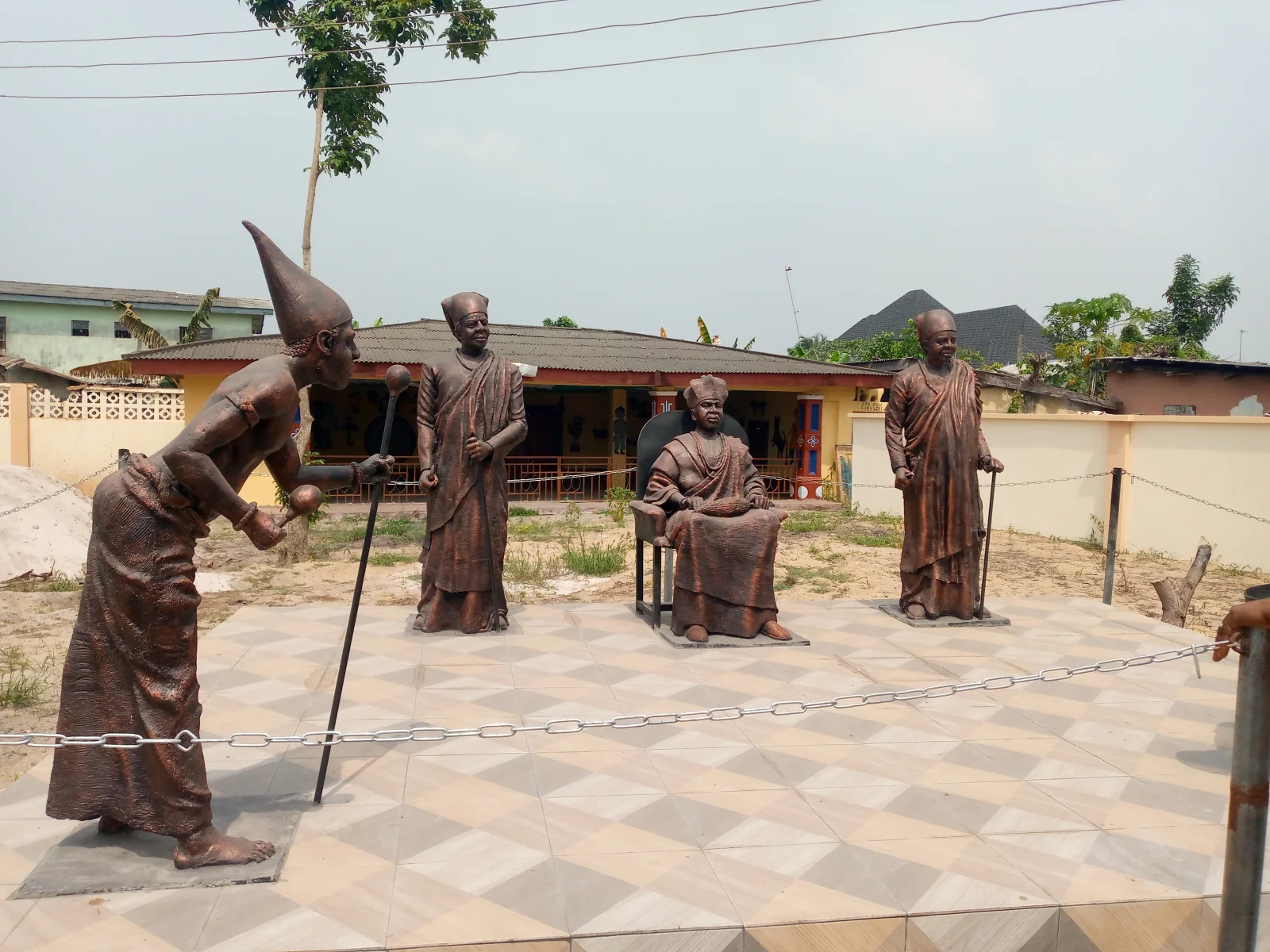 A modern sculptural tableau at Vlekete represents people and exchange around the remembered market.