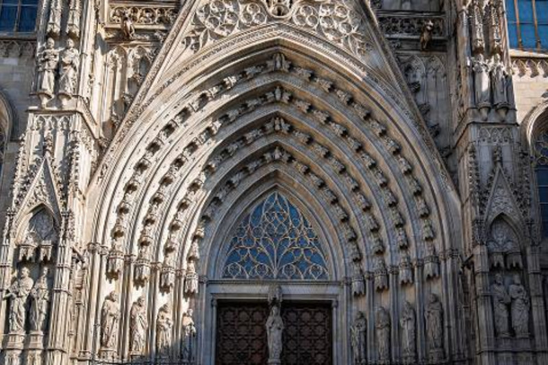 Carved stone arches and figures over a portal of Barcelona Cathedral