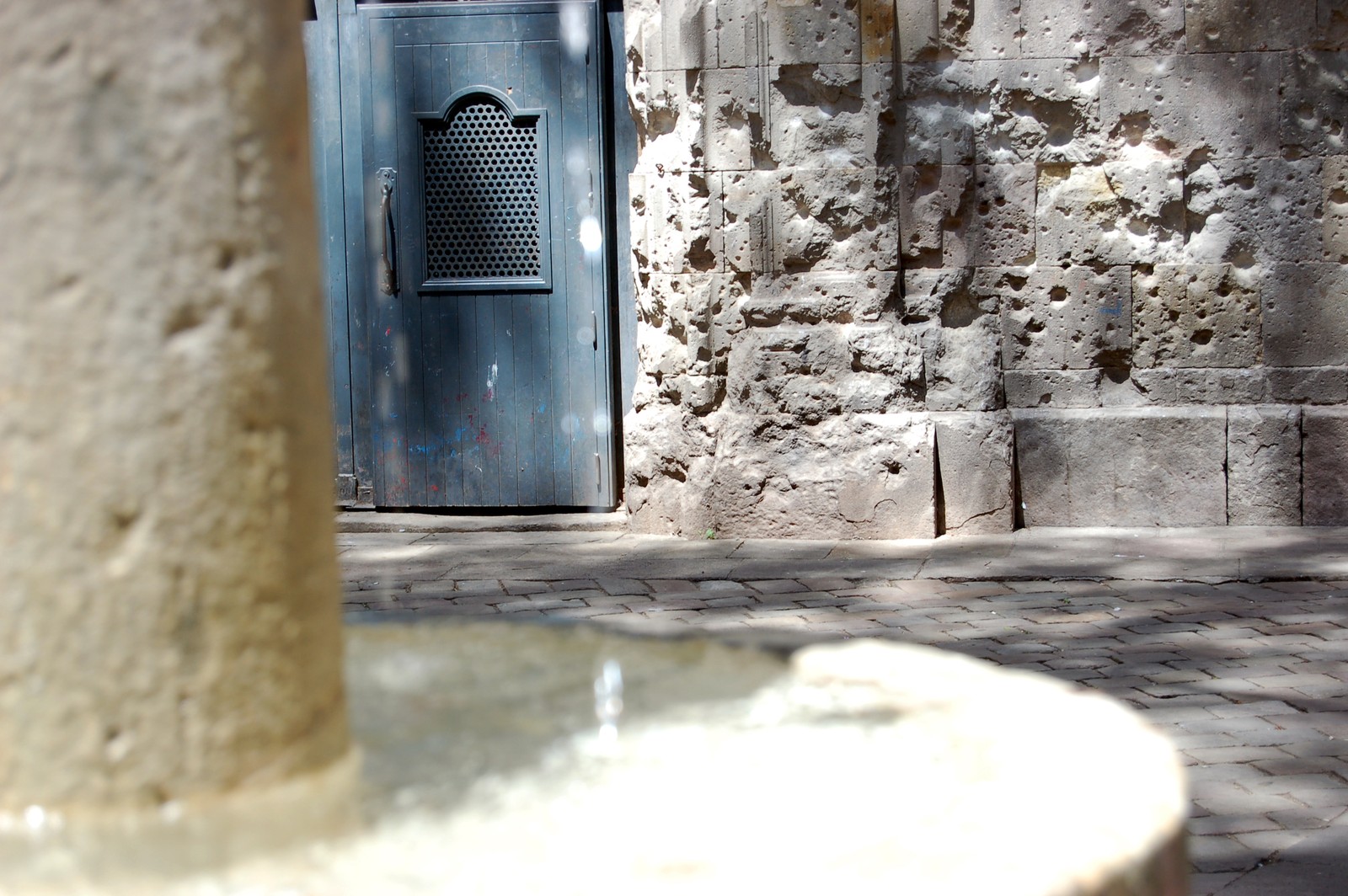 The church façade at Plaça de Sant Felip Neri carries the scars of the 30 January 1938 bombing