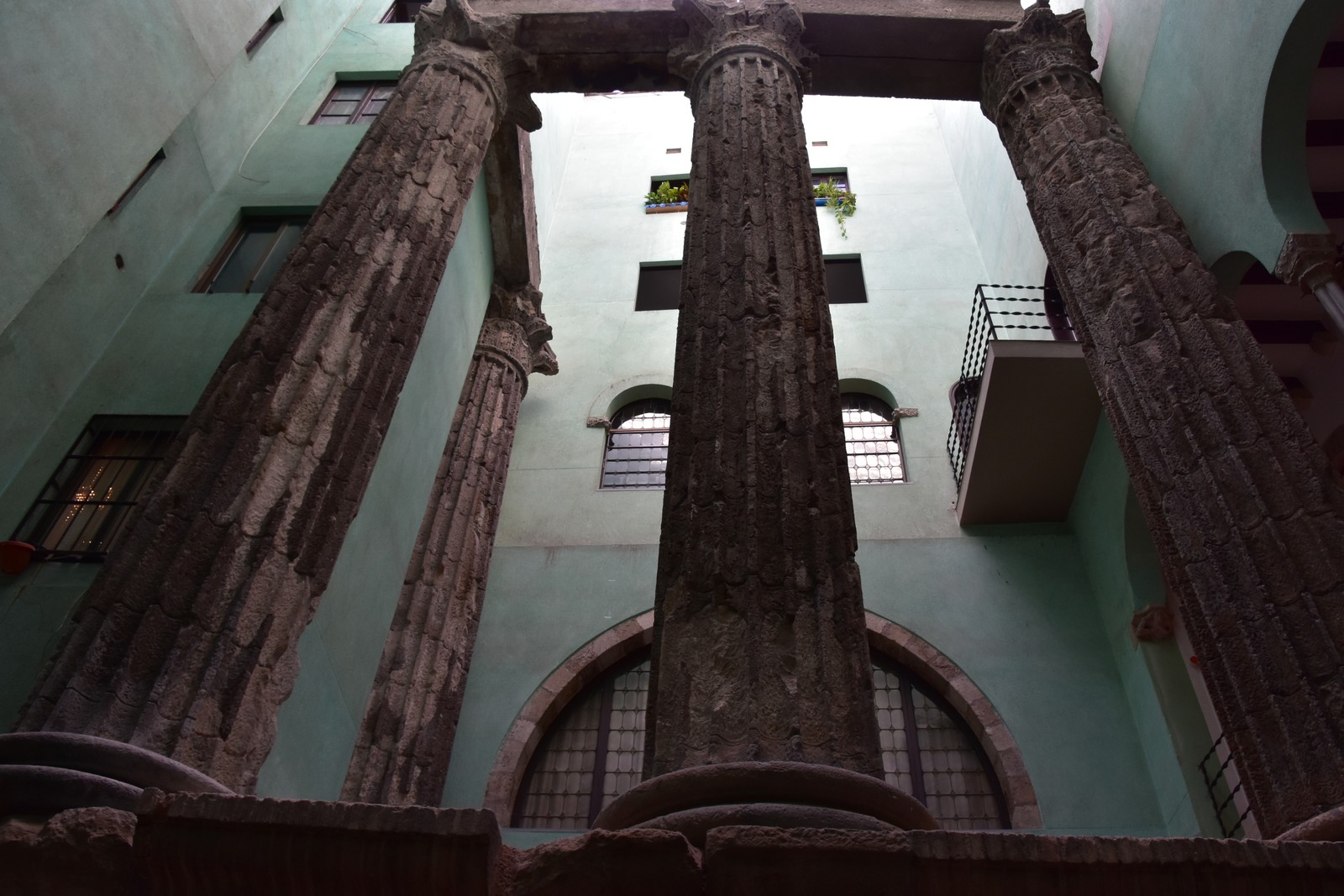 Corinthian columns and the surviving architrave of the Temple of Augustus enclosed by later walls