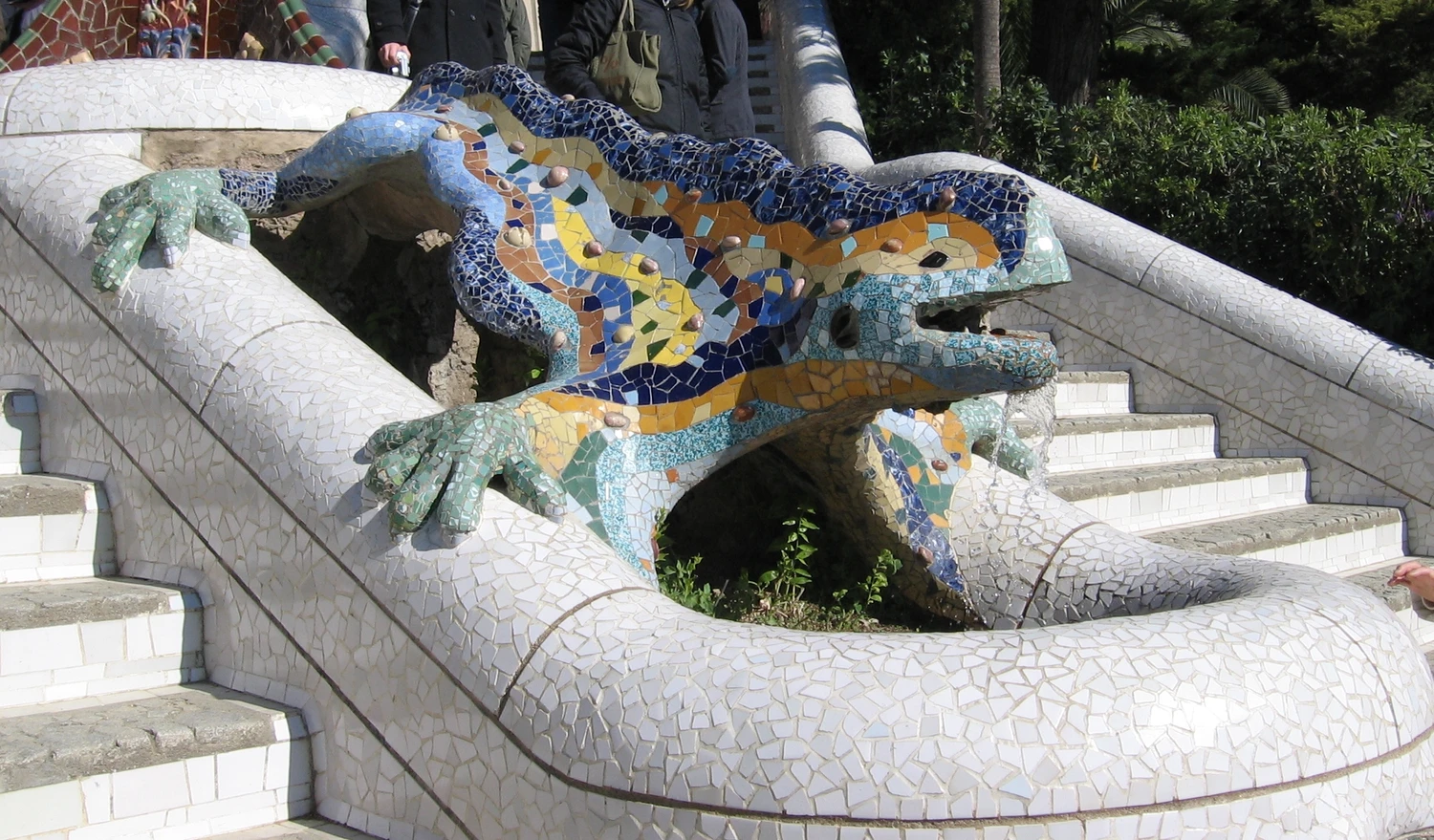 The mosaic salamander stretches over its stairway basin, showing its ceramic fragments and open mouth