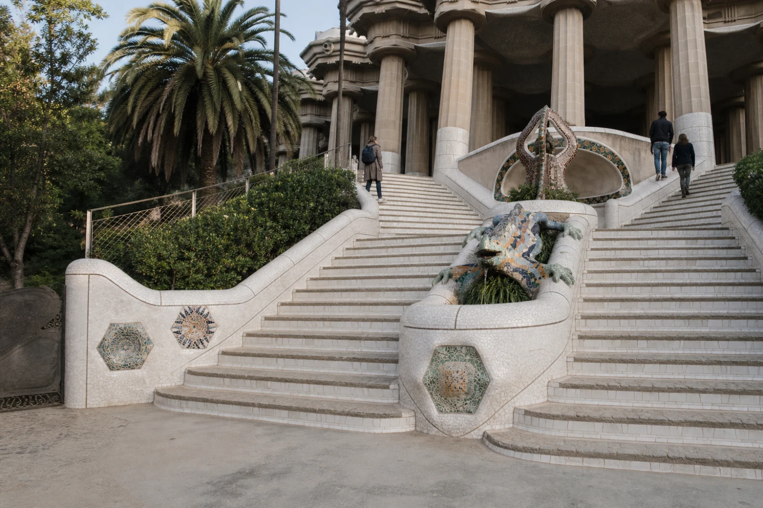 The double monumental stairway rises around basins, the Catalan emblem and the trencadís salamander