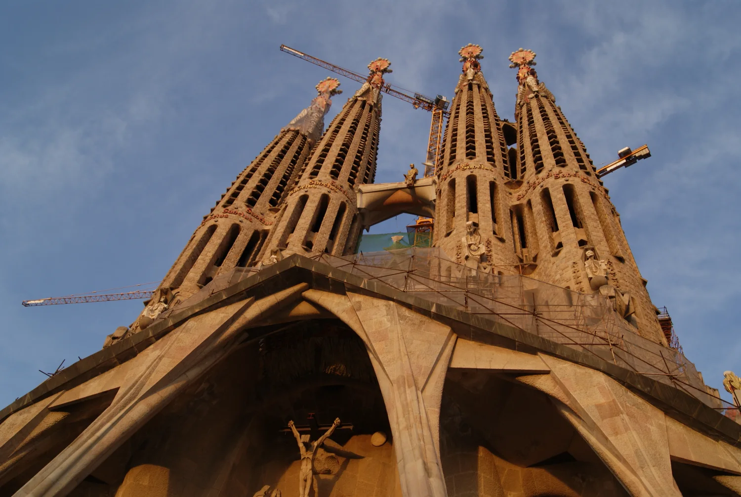 The Passion Façade in 2010 shows its severe porch, apostle towers, Subirachs sculptures and the construction setting around them