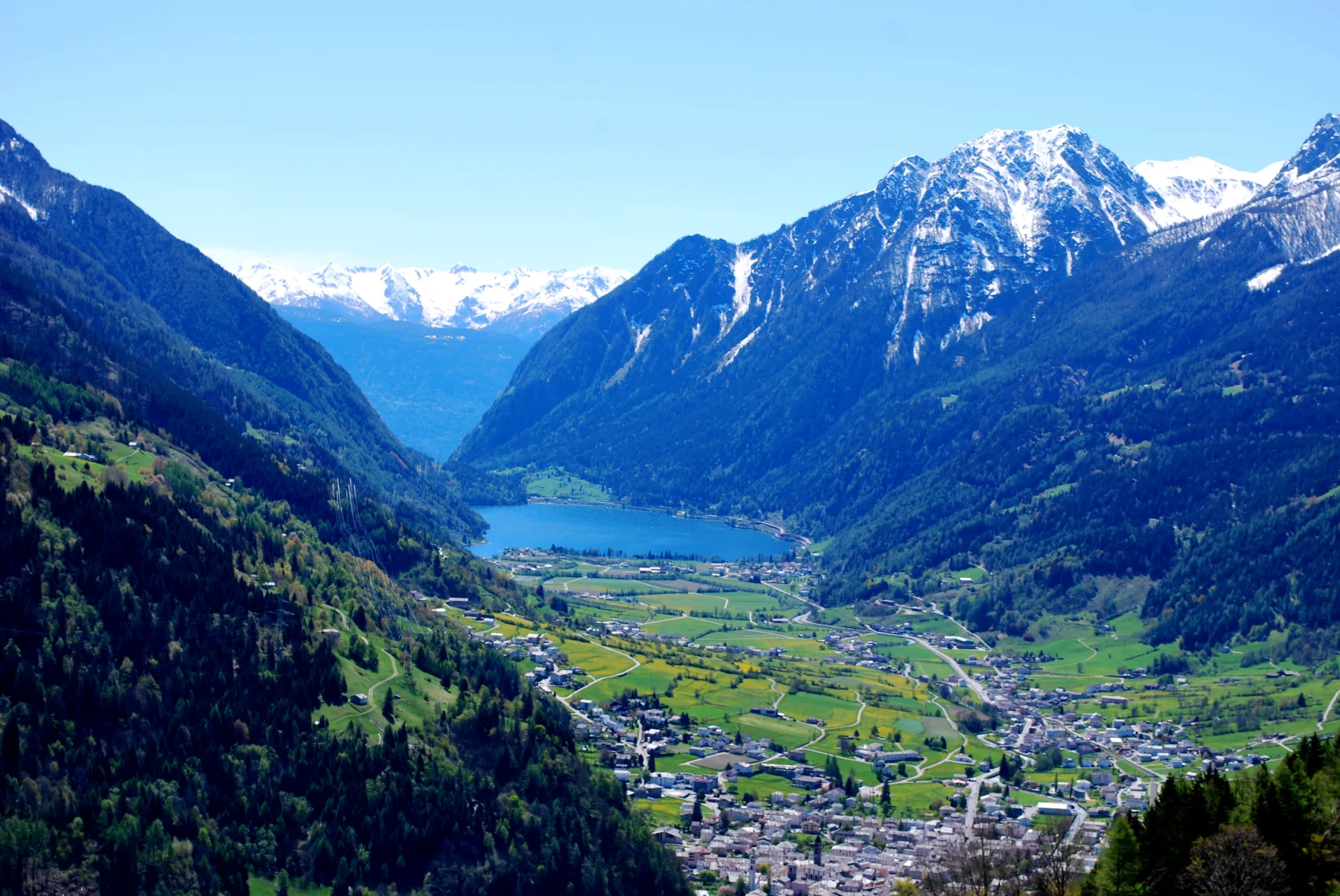 Val Poschiavo with settlements, farmland and lake beneath steep slopes