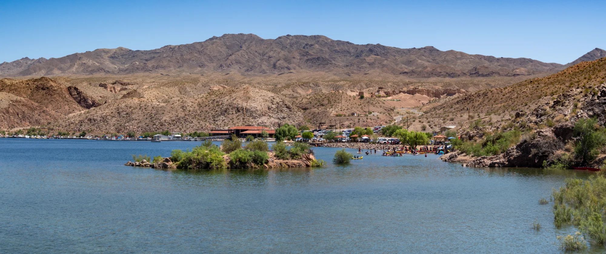 A broad view from above shows Willow Beach, its marina and the Colorado River confined by desert canyon walls.