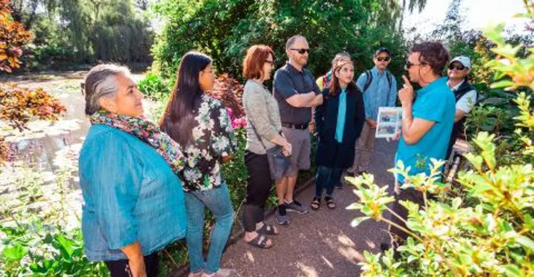 A current exact-product photograph shows a guide using a visual aid with a small group beside the Giverny water garden.