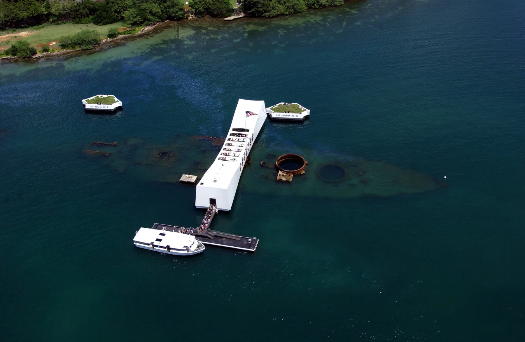 Aerial view of the USS Arizona Memorial spanning the submerged wreck.