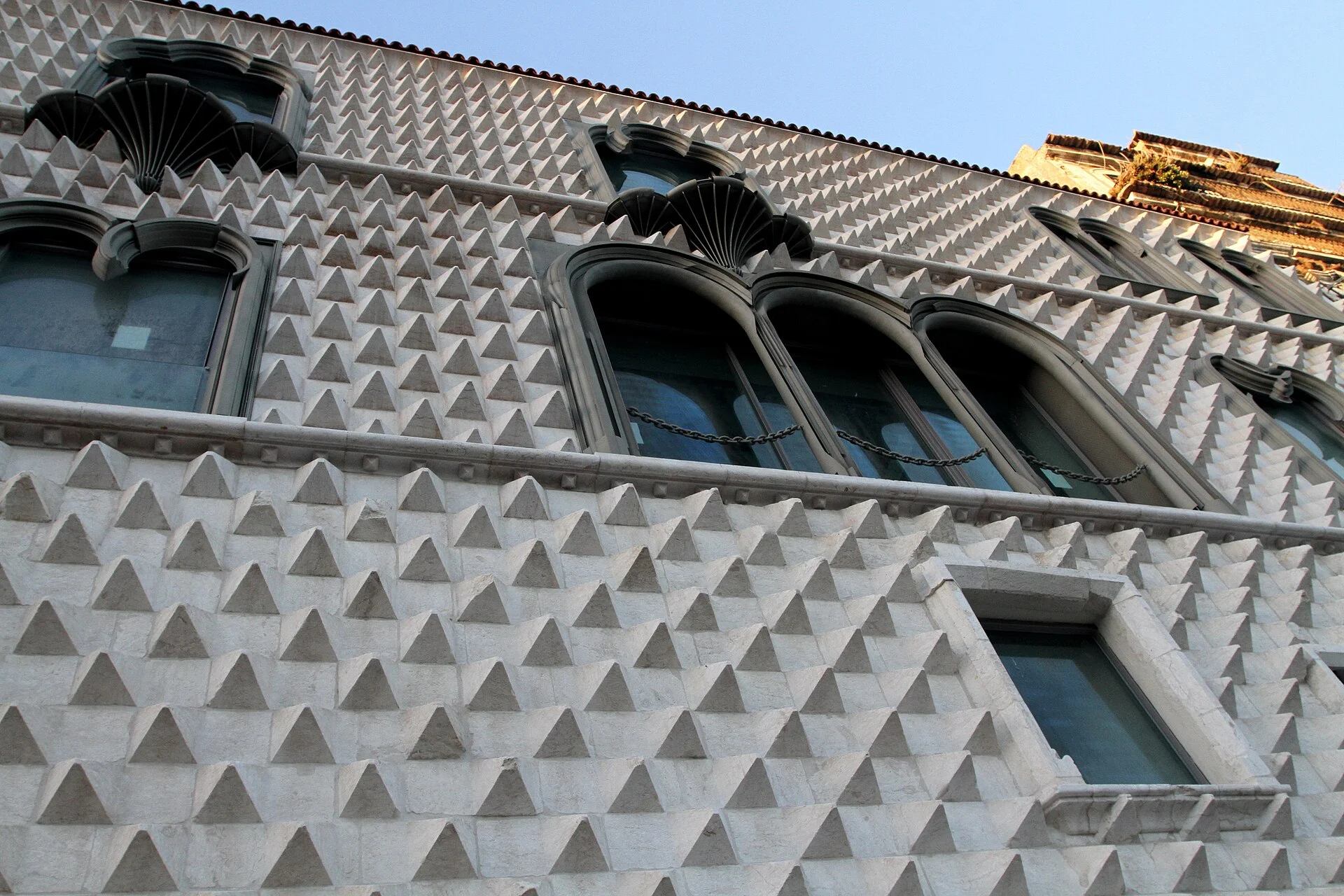 The diamond-point façade of Casa dos Bicos rises around later window openings.