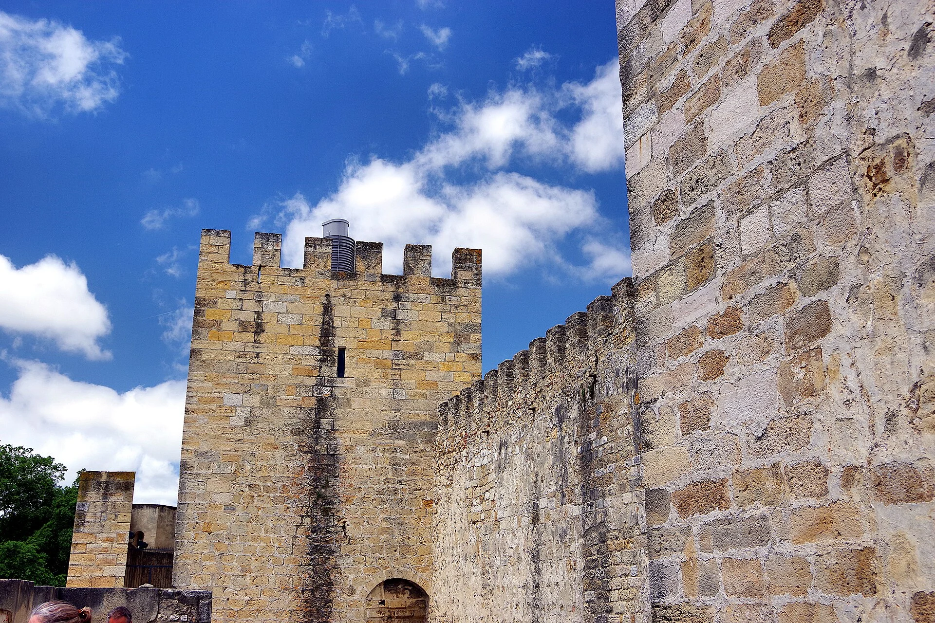 Mixed masonry, regular battlements and a restored tower show how the castle presents a legible medieval silhouette today.
