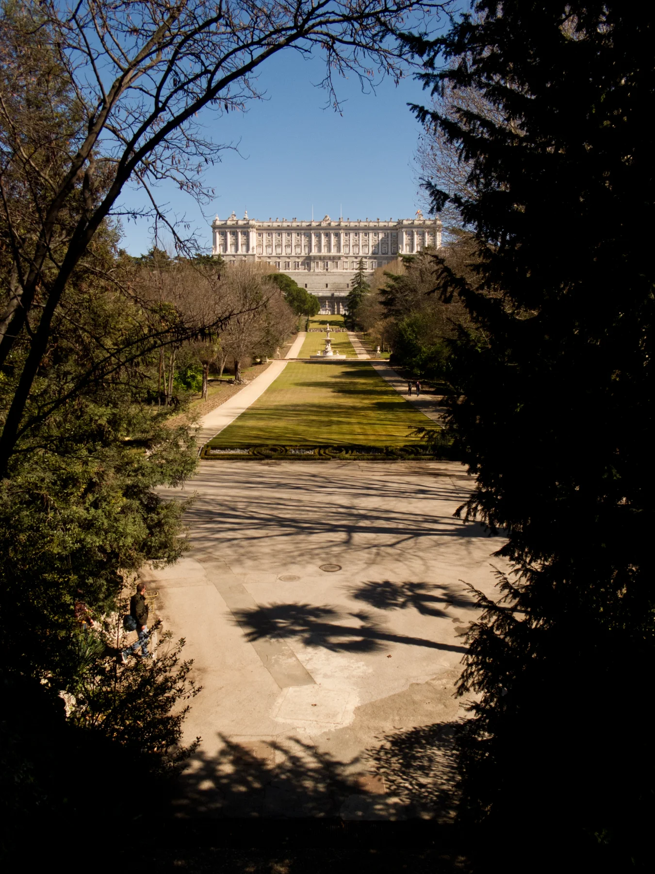 A long lawn and fountain axis rises through Campo del Moro toward the western façade of the Royal Palace.