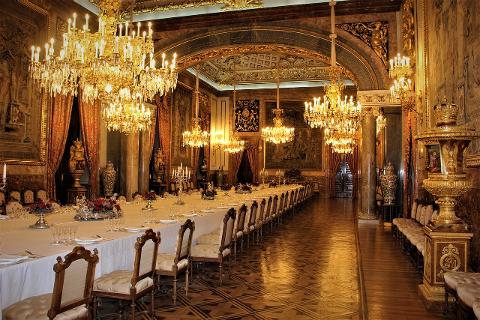 The long state dining room inside Madrid’s Royal Palace beneath chandeliers
