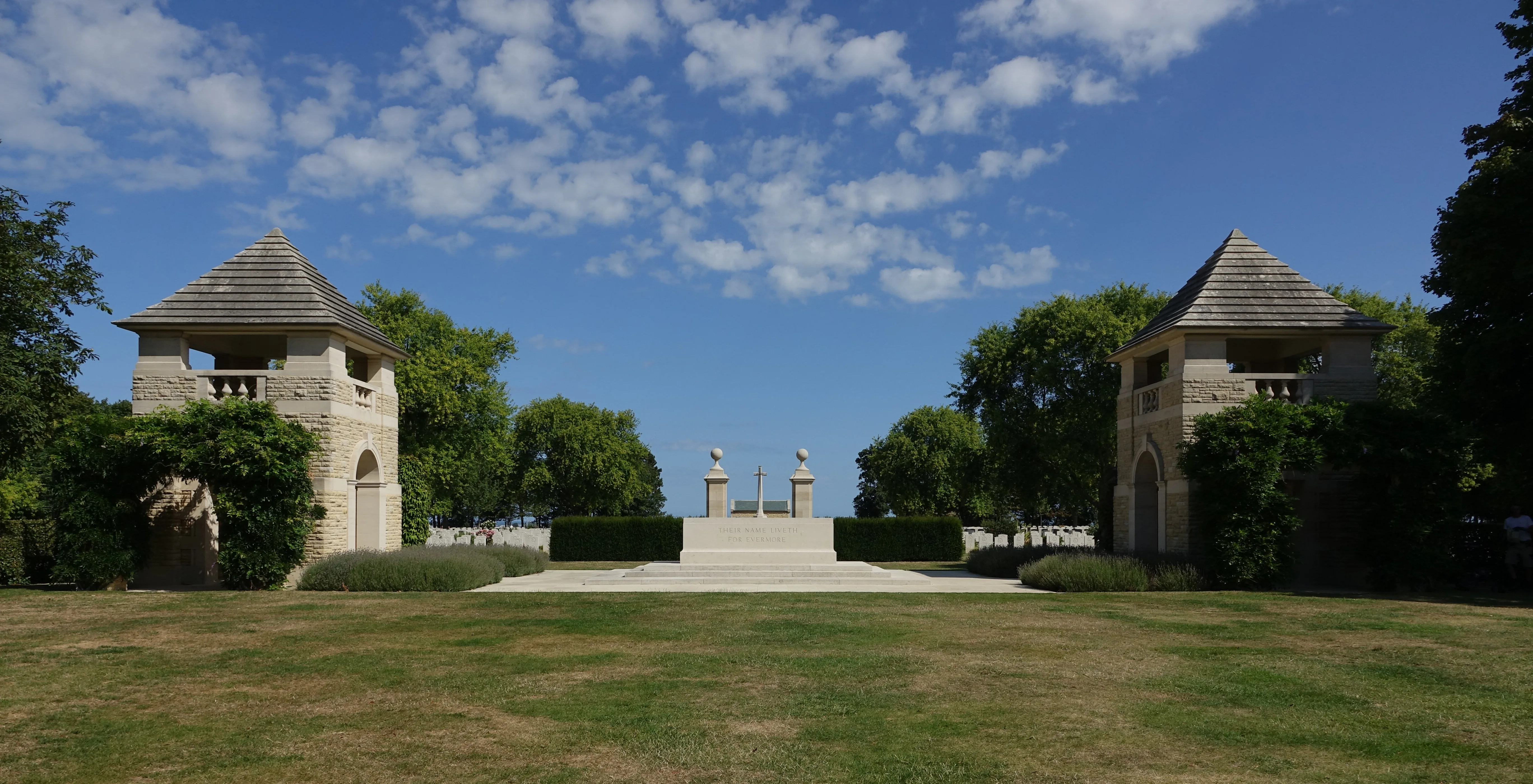 Wide view of Bény-sur-Mer Canadian War Cemetery near Reviers, with paired towers and the Stone of Remembrance