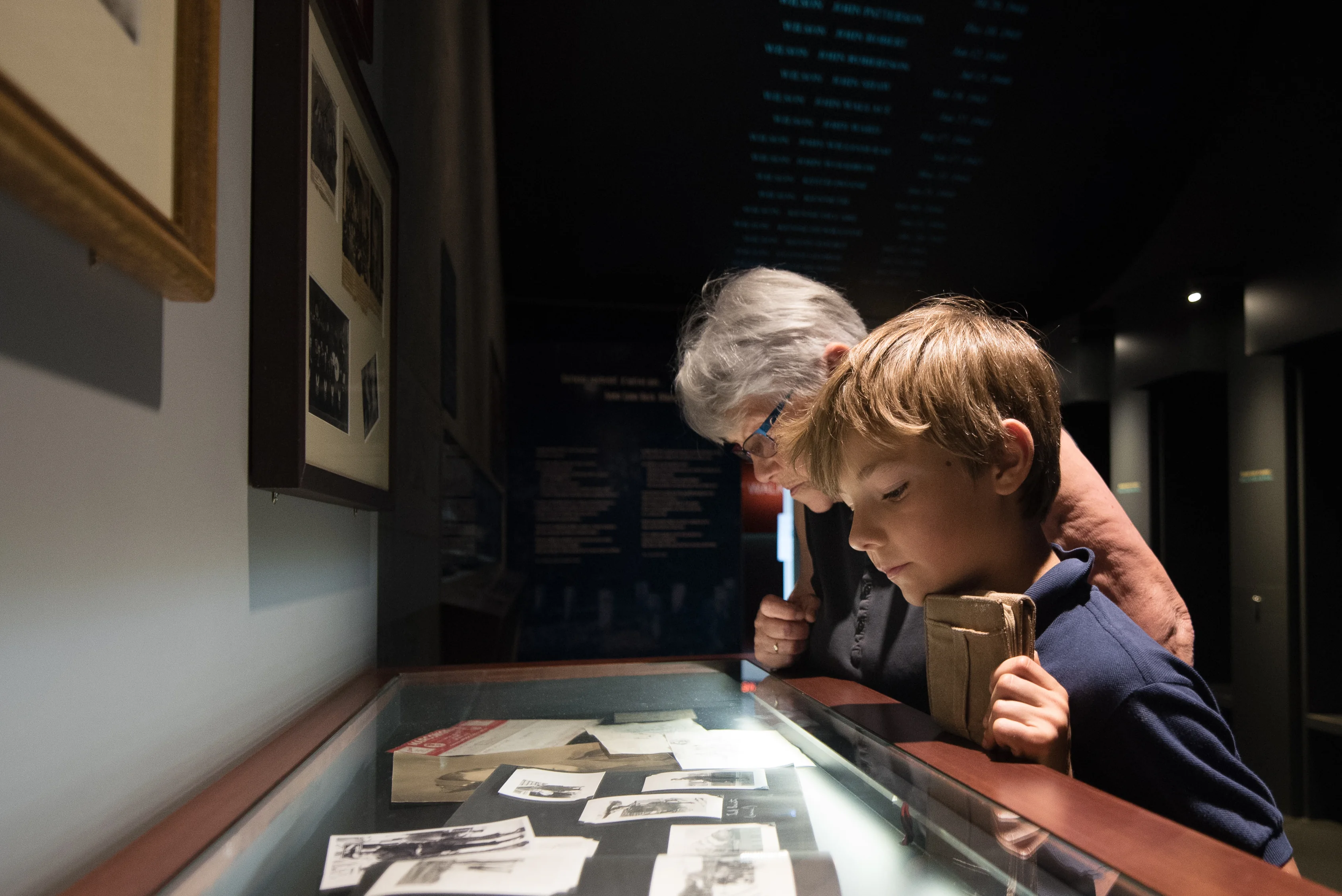An adult and child examine personal objects and photographs inside the Juno Beach Centre