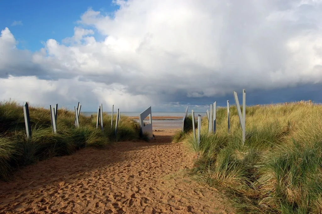 A path through Juno Park's dunes toward the beach, lined by interpreted obstacle forms
