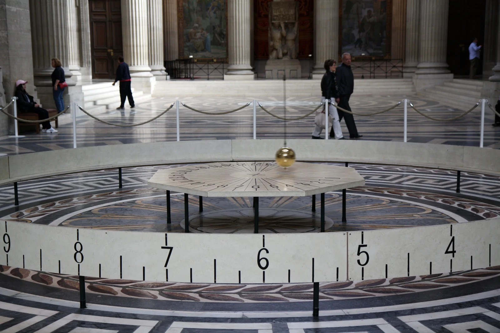 The Foucault pendulum hangs within the Panthéon’s monumental interior above its circular display.