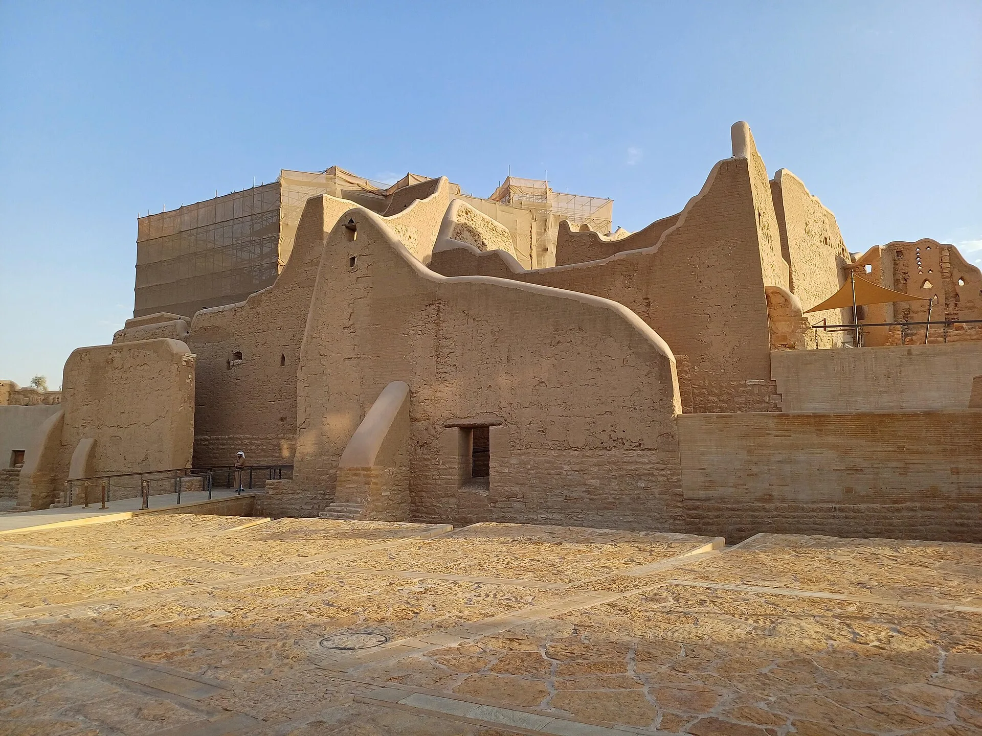 Layered earthen walls and restored visitor paths at At-Turaif show both ruin and conservation.