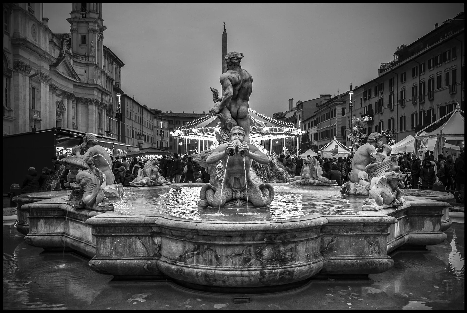 The Fountain of Neptune stands before a seasonal market and carousel in Piazza Navona.