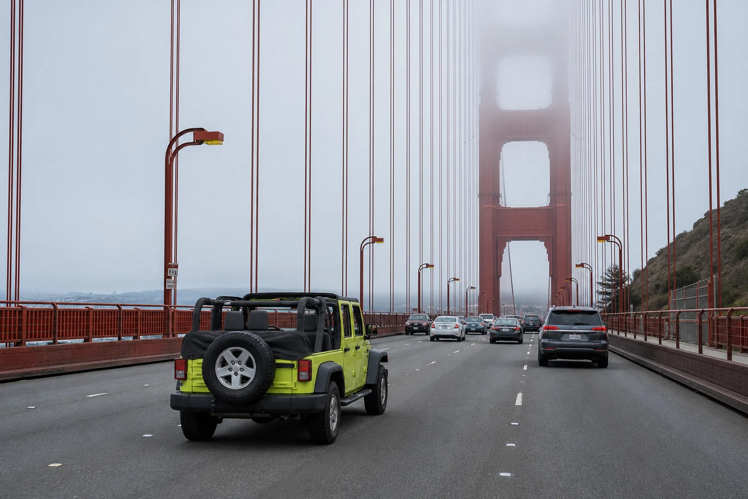 An open-top vehicle crossing the Golden Gate Bridge in coastal fog