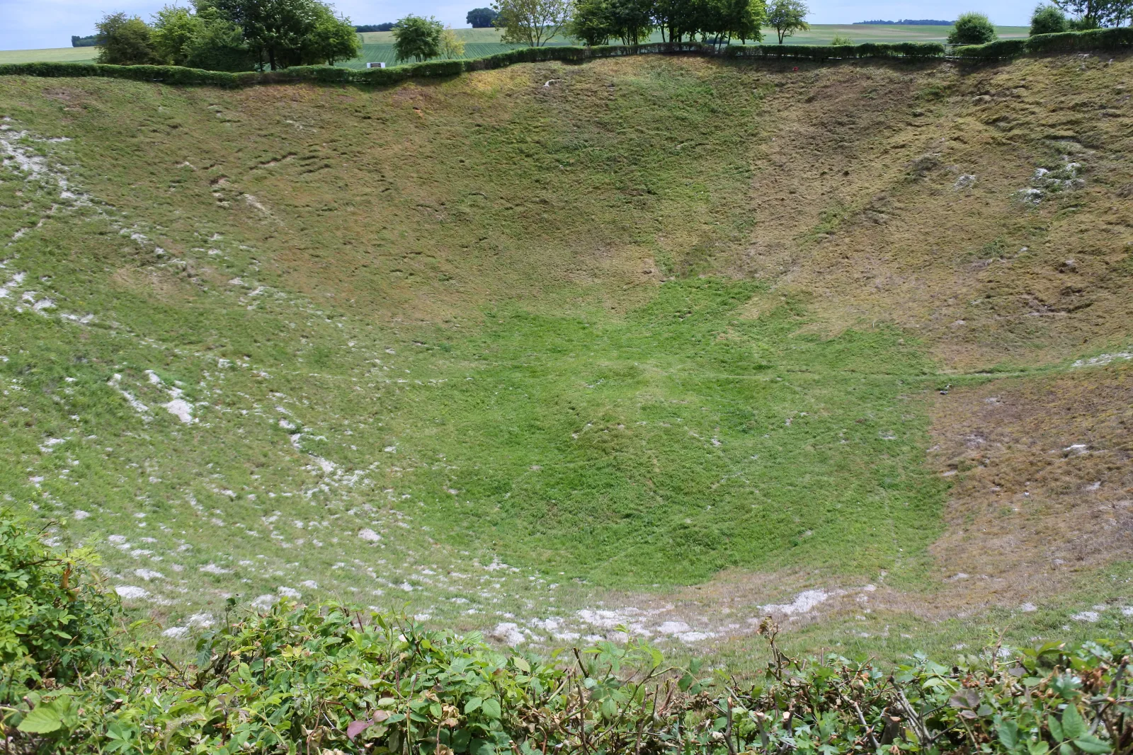 The present-day Lochnagar Crater is a broad, grassed depression surrounded by working fields.