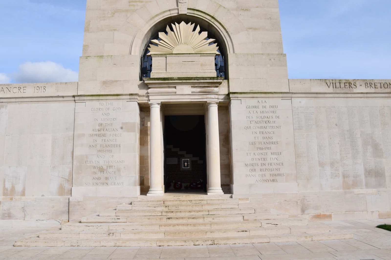 The entrance to the tower at Villers-Bretonneux, with bilingual dedication panels and the adjoining inscribed memorial walls.