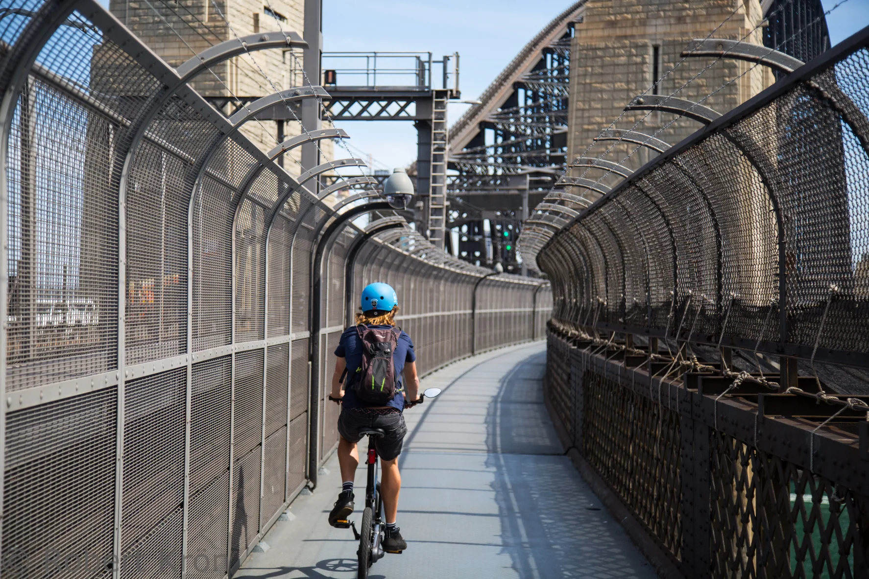 A cyclist on the protected western-deck path of the Sydney Harbour Bridge in 2015, before the southern ramp replaced the stair barrier.