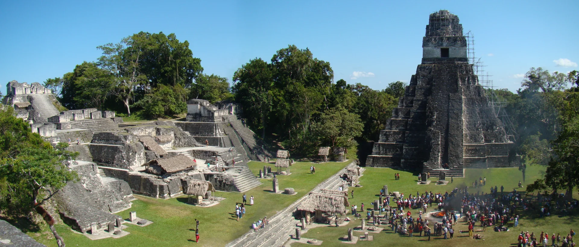 The Great Plaza and North Acropolis at Tikal, with long stone terraces and temple architecture across a broad lawn.