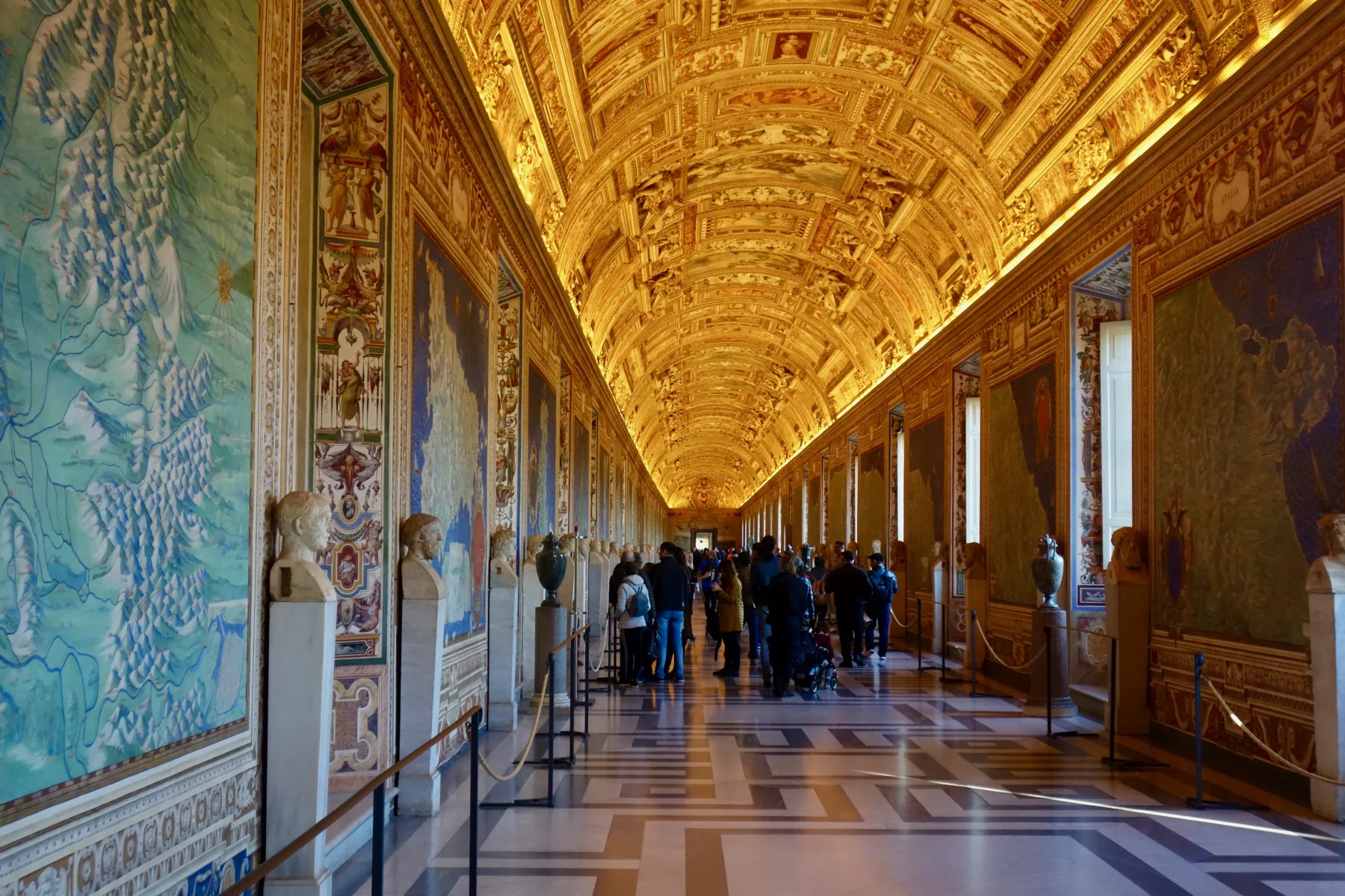 Visitors move through the frescoed Gallery of Maps in the Vatican Museums.