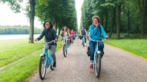 A current connected-product photograph shows a small group riding bicycles on a tree-lined park path beside water.
