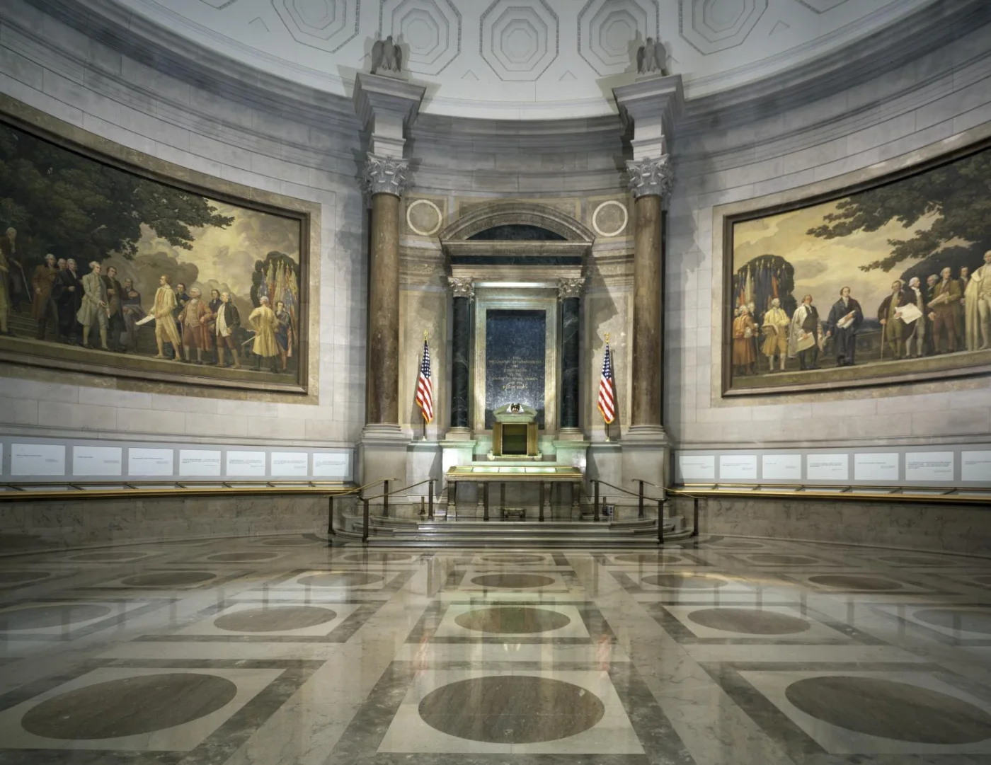 The Charters of Freedom display cases stand beneath the murals of the National Archives Rotunda.
